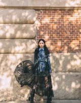 孟美岐内搭简约白衫外披复古西装，置身于暖色调光影交织的咖啡馆窗前，散发知性而松弛的韵味