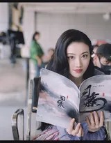 暖黄灯光下景甜手执剧本沉思，侧脸轮廓精致宛如细腻雕塑