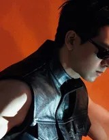 李现单手轻扶镜框做思考状，黑色背心衬托出结实手臂肌肉，背景虚化中眼神充满故事感