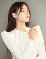 林允漫步于林间小径，阳光透过树叶在她身上投下斑驳光点，白色长裙与静谧环境融为一体，宛如森林精灵