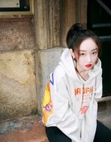 蒋梦婕在秋日光影下漫步，宽松卫衣与短裤的搭配凸显修长腿部线条，整体造型洒脱中带着一丝慵懒的惬意