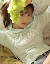 放松地向后仰靠，长发披散，享受着沙发带来的全身心支撑与舒适