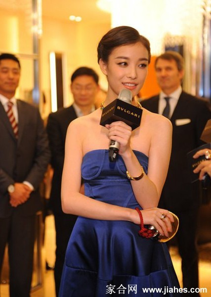 展厅内光影交错，倪妮驻足欣赏艺术珠宝，侧影轮廓如雕塑般优美