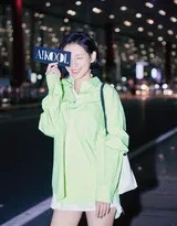 侧身立于霓虹之下，光影分割出明暗交界，张予曦的侧颜在夜色中显得神秘而迷人