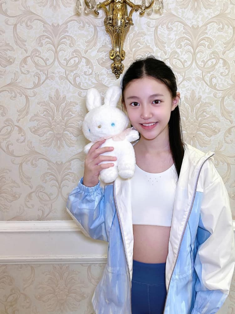 春日校园中，少女手持书本微笑