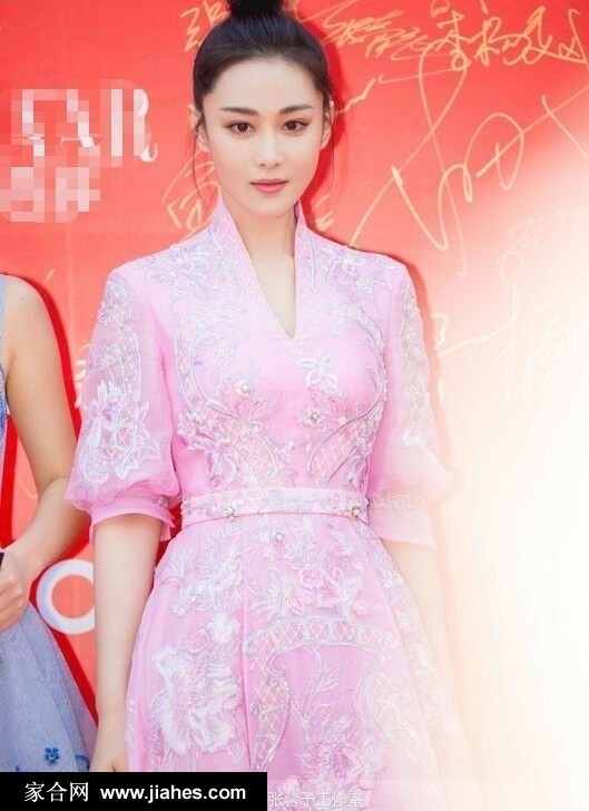 张馨予展露温婉笑容，粉色礼服在灯光下泛起柔和光泽