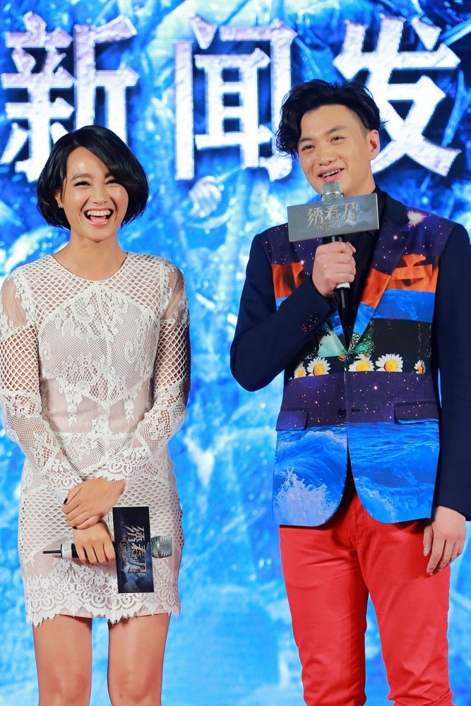 朱丹手持话筒自信微笑，聚光灯下肌肤胜雪，短发造型利落飒爽