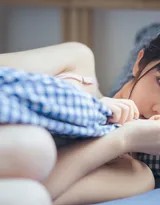 仰卧床上，蕾丝花纹在胸前蔓延，放松姿态中透出自信光芒