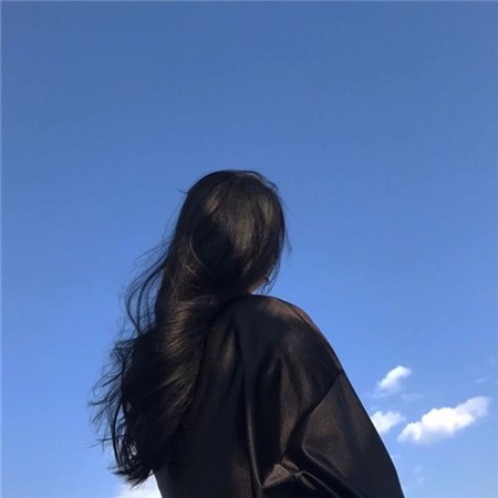 海边日落时分，女孩赤脚走在沙滩上，海浪轻抚脚踝，她的背影面向绚烂的晚霞，壮丽景色反而衬托出个体的渺小与孤寂。