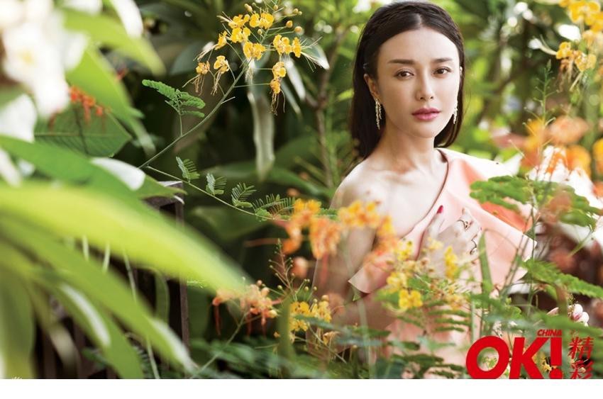 秦岚倚靠石墙露出优美肩颈线与美背，简约服饰与繁复背景对比强烈，勾勒出极致优雅的剪影