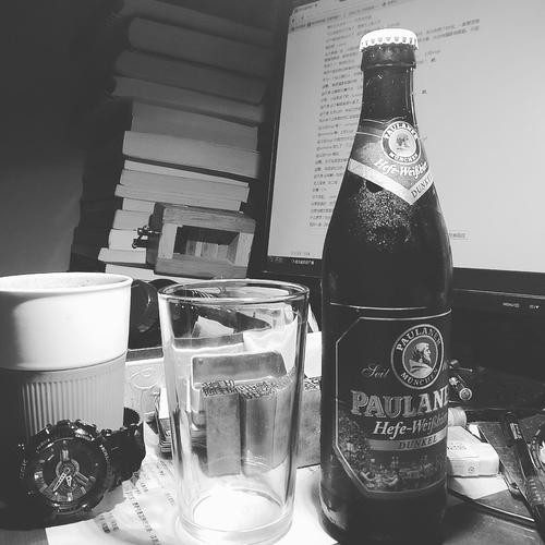 特写手中的威士忌酒杯，琥珀色酒液与冰块折射出都市霓虹的孤独光影