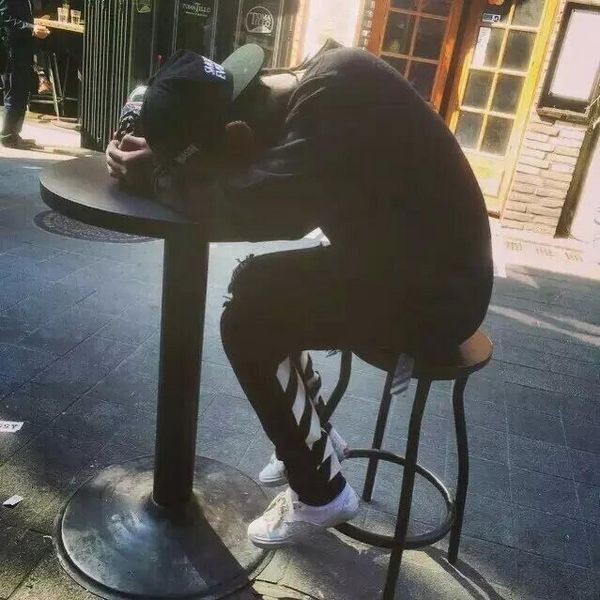 一个男人深深埋首于双掌之中，仿佛想将自己从喧嚣世界彻底隔绝，肩颈线条诉说着无法承载的疲惫