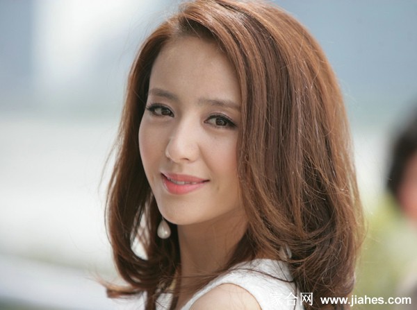 佟丽娅低头浅笑手指轻触唇角，细腻演技在特写镜头中展露无遗，眼中闪烁着温柔而复杂的情感光芒