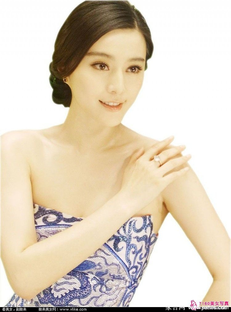 一袭红色深V礼服勾勒出曼妙曲线，范冰冰手持团扇半遮面，笑意盈盈中带著一丝神秘与挑逗。