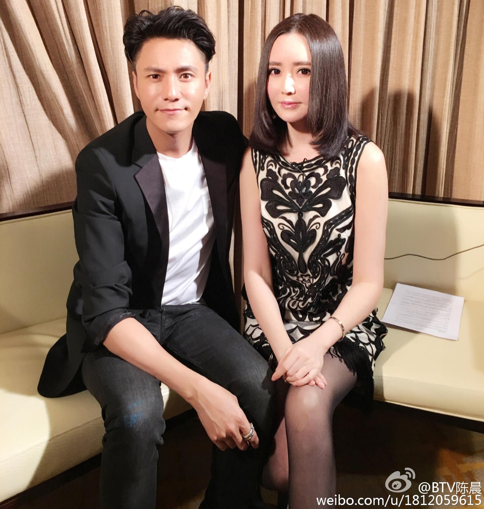 陈晨身着优雅套裙侧身微笑 手持话筒展现专业姿态