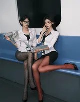 其中一位海妖单手插袋倚靠售票机，另一位置身于自动门的光影中，玻璃的反射模糊了真实与倒影的界限，构成一幅虚实交错的都市画面。
