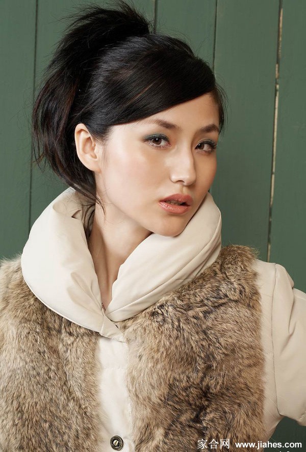 蓝心妍侧身倚靠篱笆，自然光影勾勒其柔和侧颜与优美身型曲线