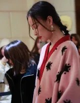 倪妮展露灿烂笑容，置身于光影之中，粉绒长衫衬托出她明媚愉悦的生动神态