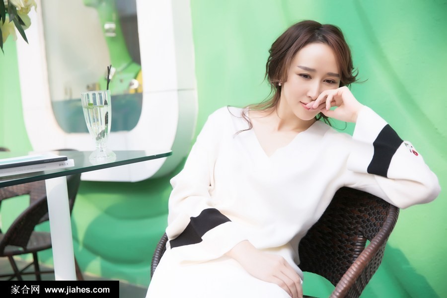胡静漫步于咖啡馆外砖石小径，微风轻拂发丝，她回眸浅笑，仿佛瞬间被某个愉悦思绪点亮，画面充满动态的故事感