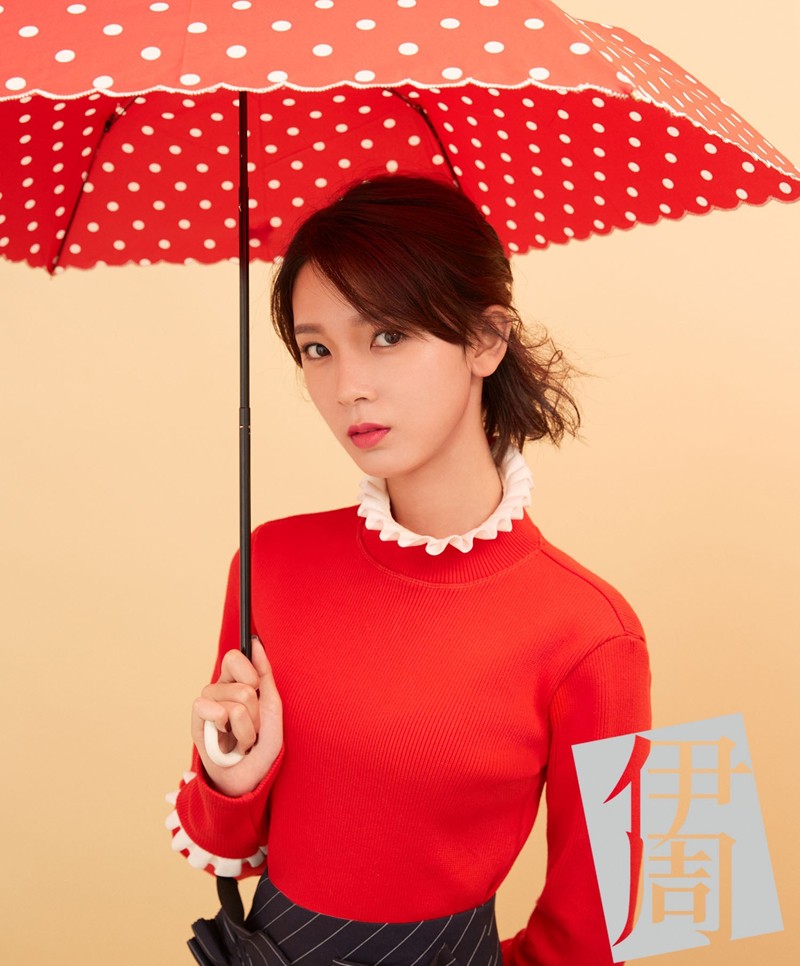 陈瑶撑一把粉色花纹油纸伞，白衣飘逸漫步于朦胧背景中，尽显烟雨江南的诗意