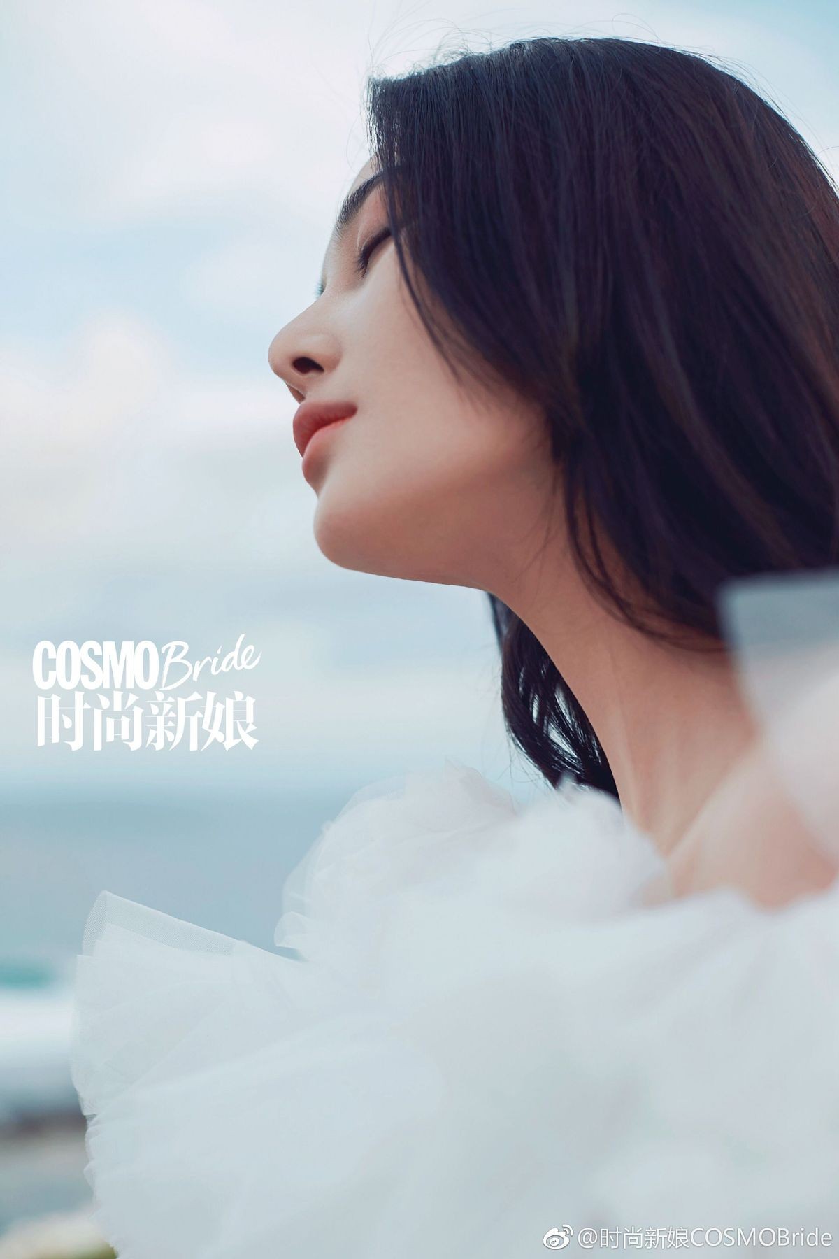 张馨予身着白色露肩装立于雪中，逆光发丝染上金色光晕宛如古早女神