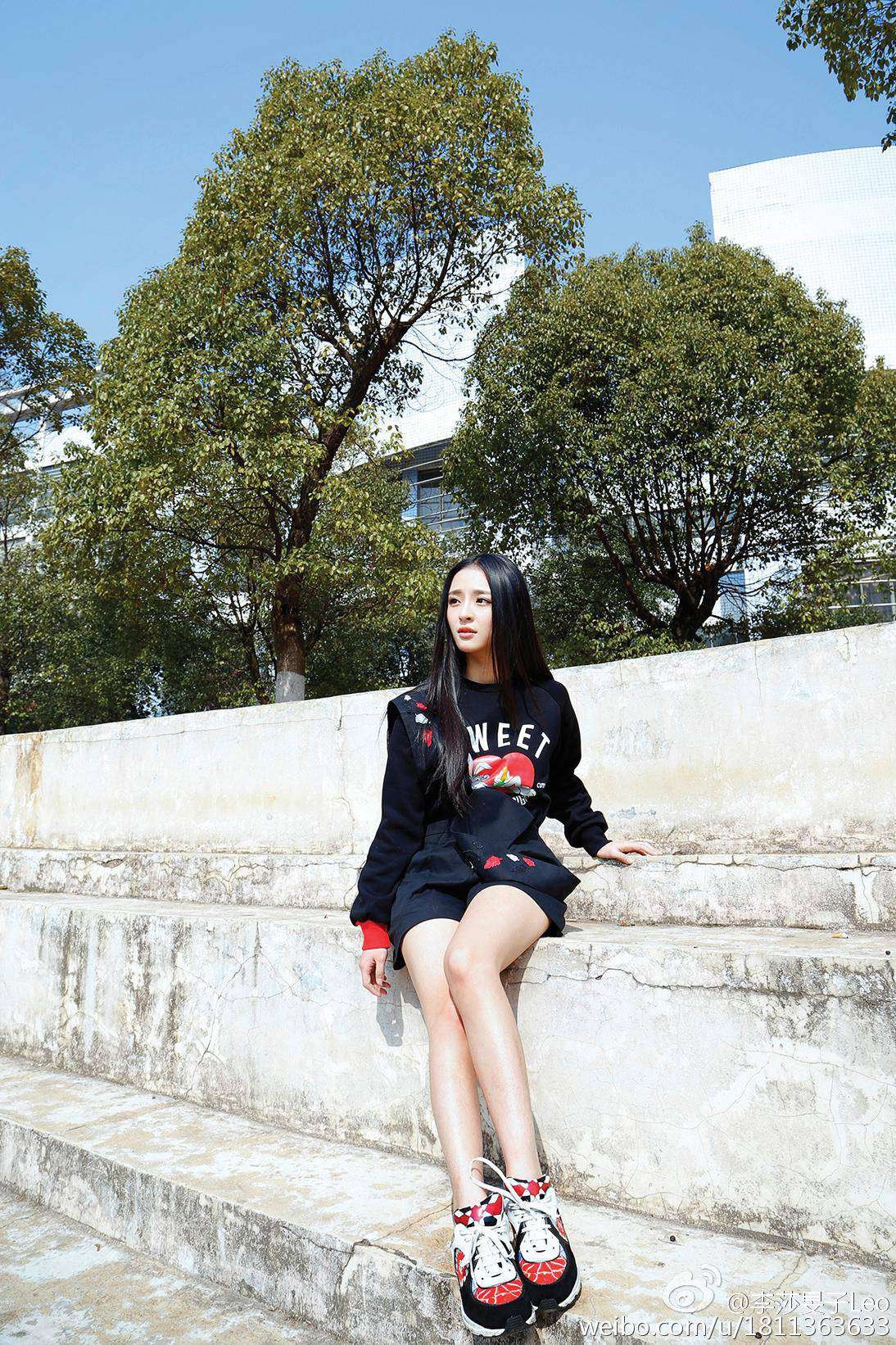李莎旻子坐在石阶上，双腿自然交叠，身后是斑驳树影，画面宁静美好